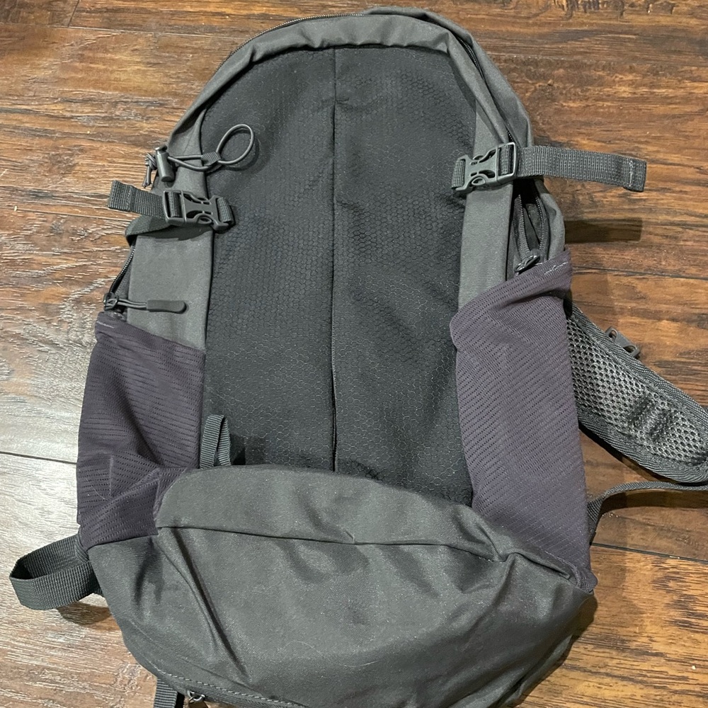 Hiking/travel backpack with poncho attached in enclosed zipper underneath.